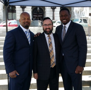 On the steps of the PA State Capitol, Rabbi Sadwin poses with former NFL star and product of nonpublic schools, Rickey Watters (on right), and with Otto Banks, the executive director of the Reach Foundation, PA's school choice coalition.
