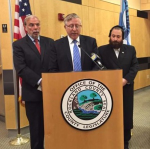 Rabbi Yosef Chaim Golding COO of Agudath Israel of America speaking at a press conference flanked by Assemblyman Dov Hikind and Rockland County legislator Aron Wieder